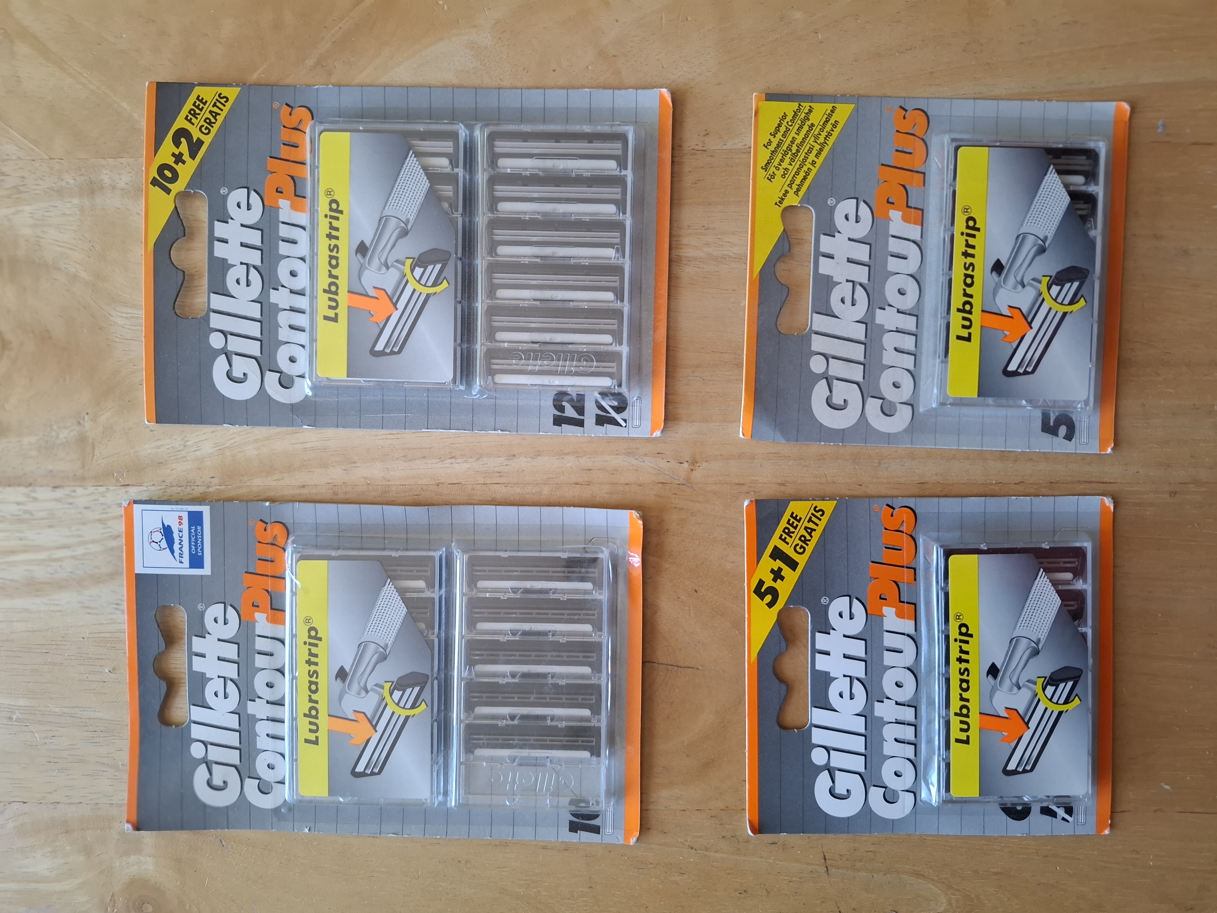 Four Gillette Contour Plus Lubrastrip blister packs, showing cartridge count and promotional banners