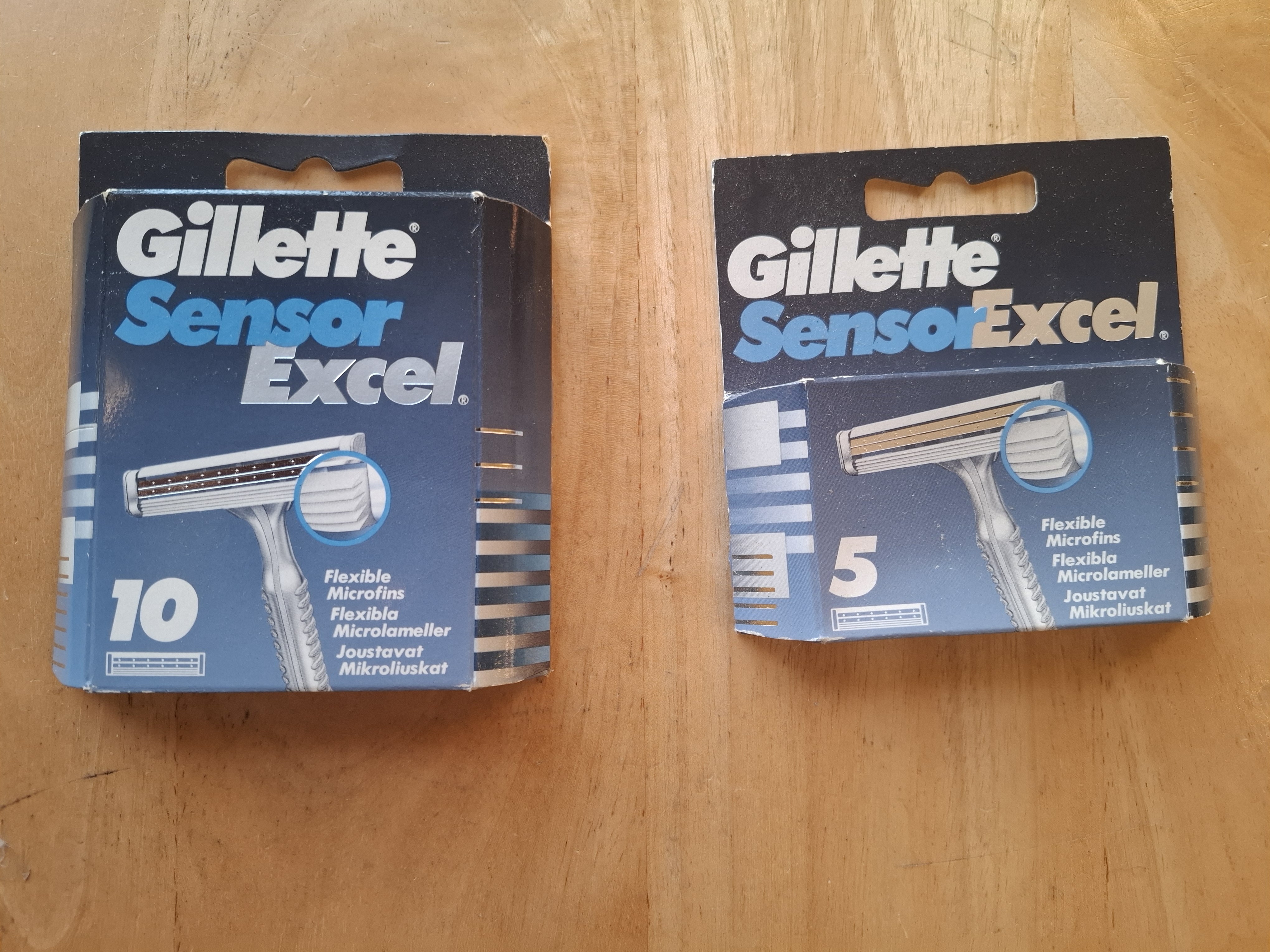 Two Gillette Sensor Excel cartons, a 10-cartridge box and a 5-cartridge box, showing navy/silver livery and microfin callout
